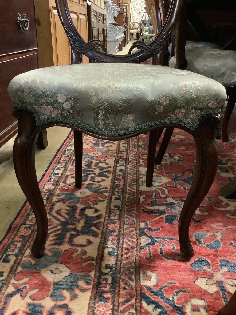 A set of four Victorian walnut balloon back dining chairs